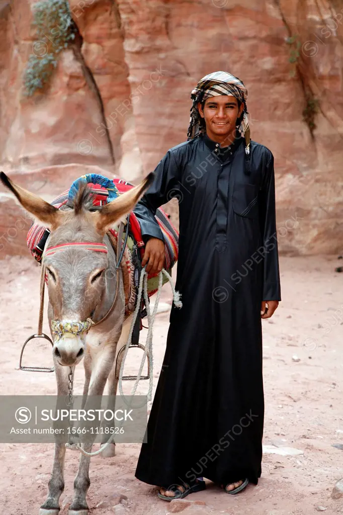 Portrait of a young bedouin man with his donky, Petra, Jordan