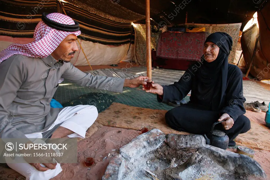 Bedouin man and his mother sitting inside a tent drinking tea, Wadi Rum, Jordan