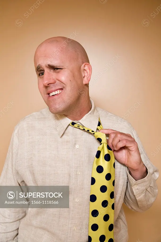Middle-age bald man pulling on his tie