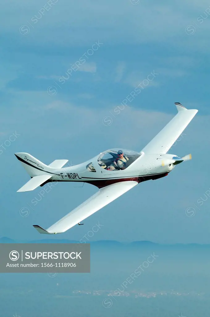 Small sport European LSA Aerospool Dynamic Turbo plane flying over France. Back the german Black Forest mountains range