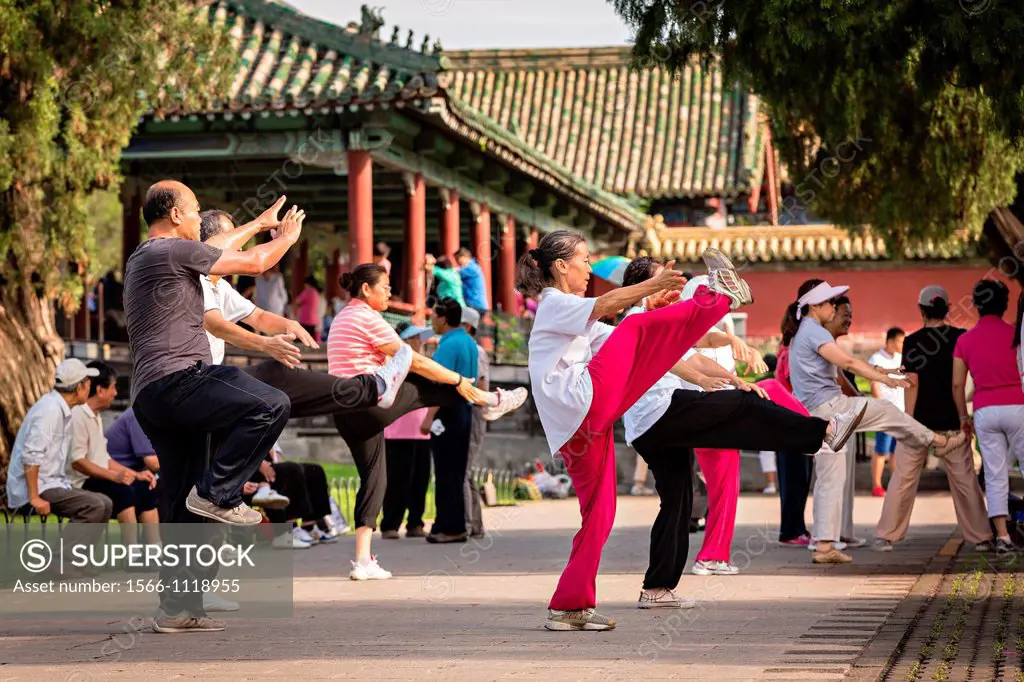 Chinese people practice tai chi martial arts exercise early morning at the Temple of Heaven Park during summer in Beijing, China