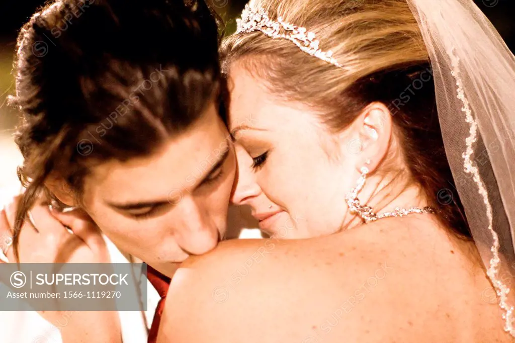 happy groom kissing brides shoulder after wedding