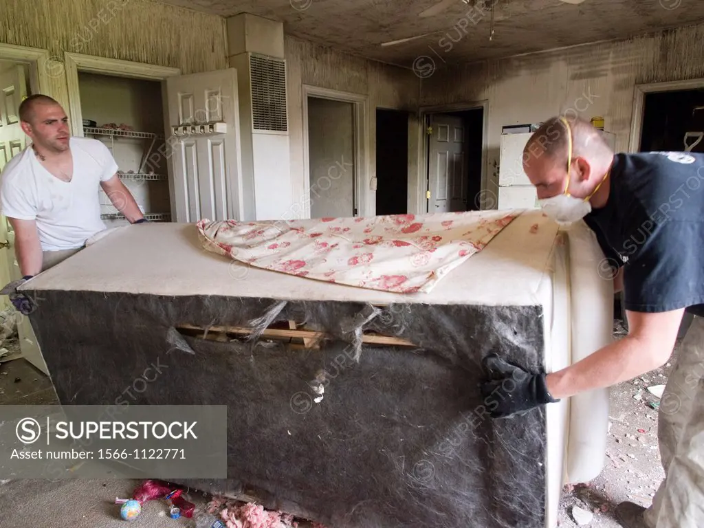 Two men remove items from a foreclosed house in Woonsocket, Rhode Island, United States