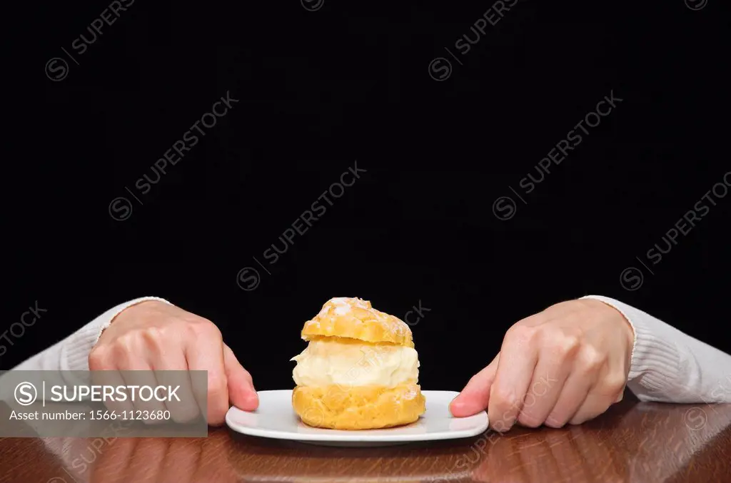 Womans hands reaching for a cake on table