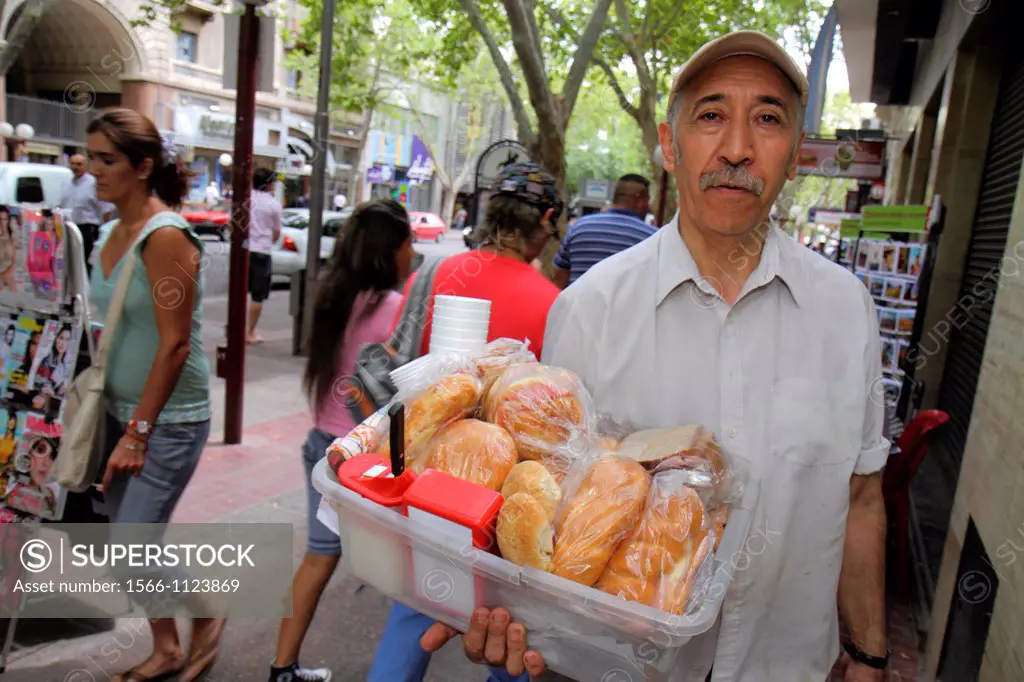 Argentina, Mendoza, Avenida San Martin, sidewalk, street scene, Hispanic, man, hawker, street vendor, sandwich maker, plastic bin, bread,