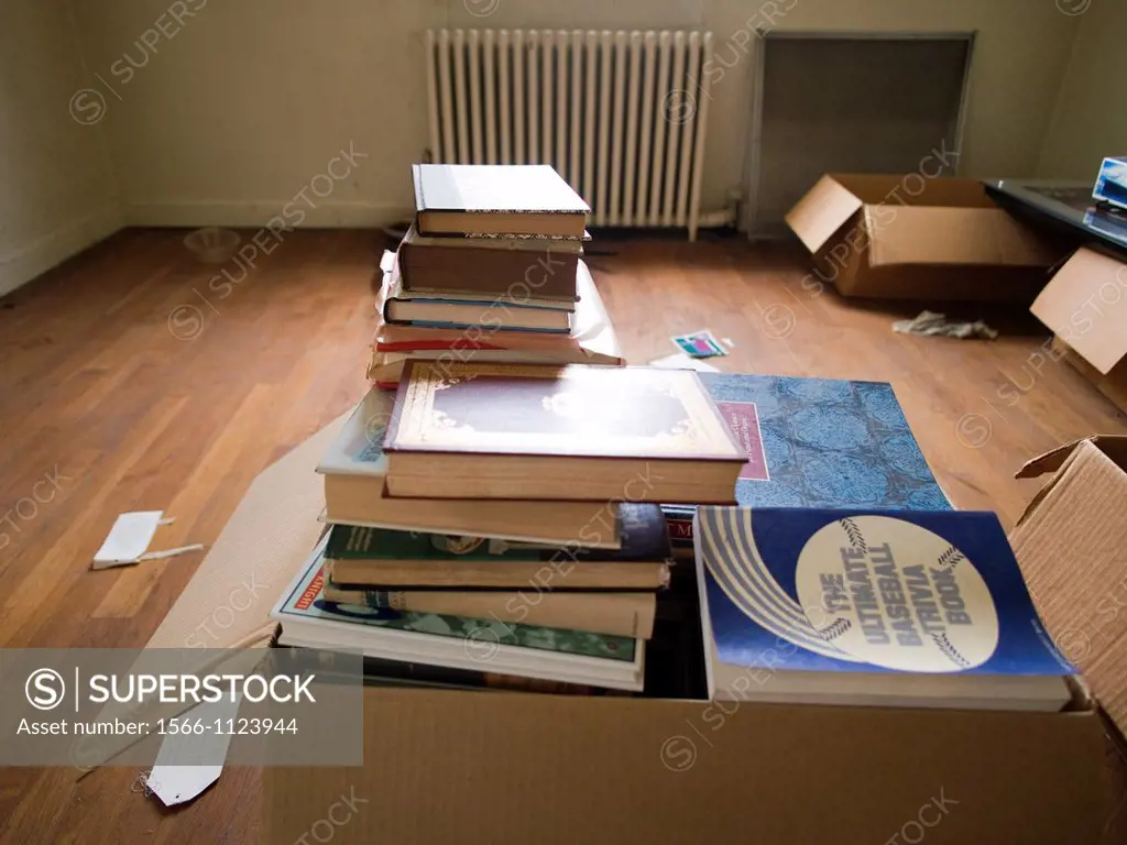 Pile of books in cardboard box inside of a foreclosed house in Bronx, New York, United States