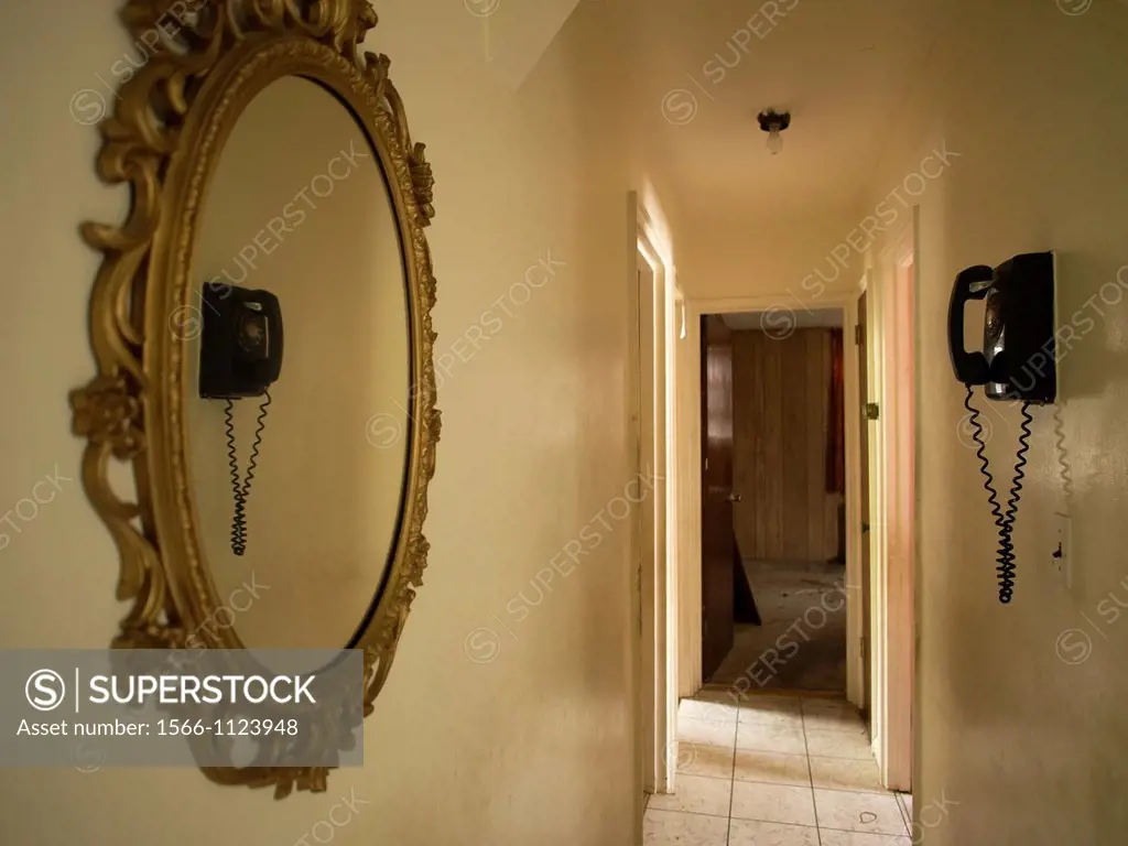 Reflection of telephone in empty hallway inside of a foreclosed house in Bronx, New York, United States