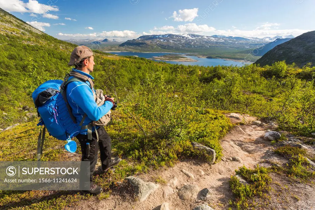 Man hiking and watching view over stora sjöfallets national park in Gällivare, Swedish lapland.