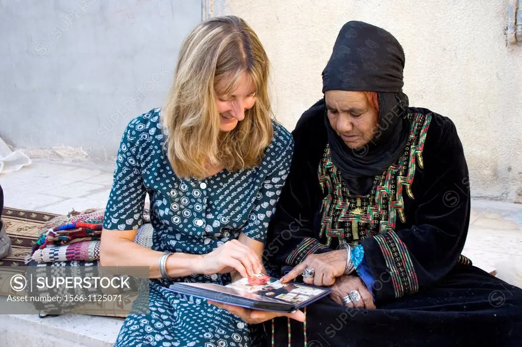 tourist with a Bedouin woman in the village of Um-Sayhoun where are living the most part of Bedoins working on the Petra site, Jordan, Middle East, As...