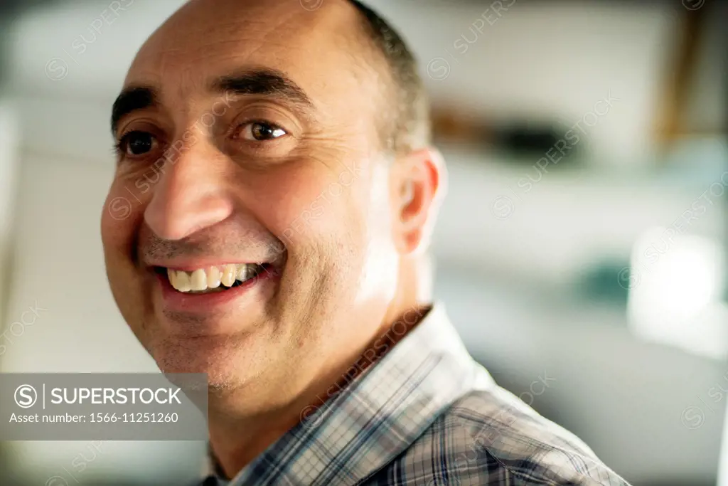 Close-up of the face of a 40-year-old Caucasian man, smiling and with positive attitude.