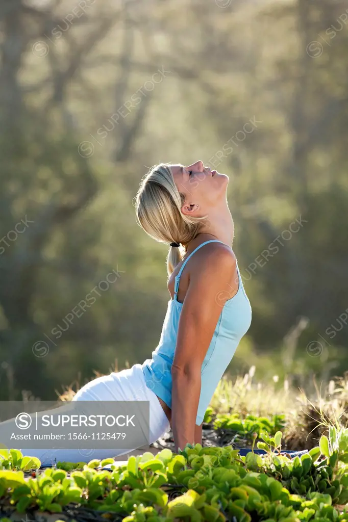 Attractive woman practices yoga at Makena, Maui, Hawaii