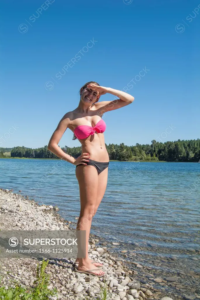 A sixteen year old girl in a bikini stands by a lake in southern Alberta, Canada