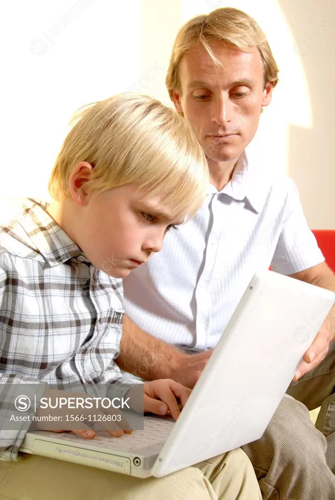 Laptop use  Father teaching his son to type on a laptop computer
