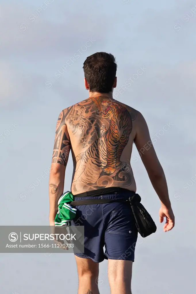 Man wearing a big and colorful tattoo on his back.