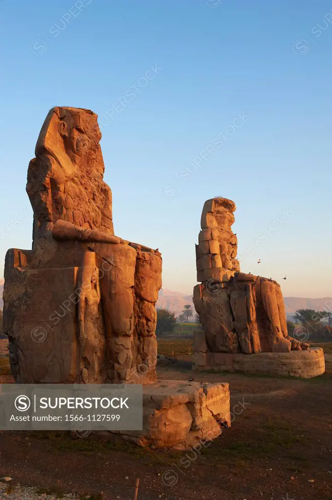 Egypt, Nile Valley, Luxor, Thebes, West bank of the River Nile, Two giant statues known as the Colossi of Memnon carved to represent the pharaoh Amenh...