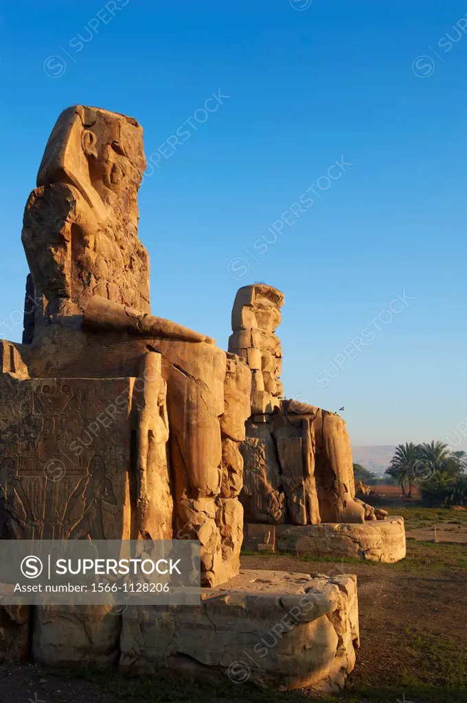 Egypt, Nile Valley, Luxor, Thebes, West bank of the River Nile, Two giant statues known as the Colossi of Memnon carved to represent the pharaoh Amenh...