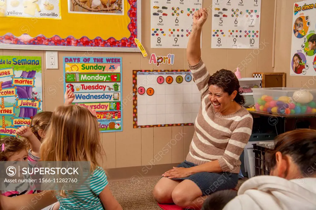 Explaining the calendar with enthusiasm, a Hispanic teacher works with young children and their parents at a ""Learning Link"" classroom in Tustin, CA...