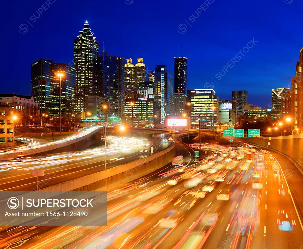 Skyline view of Atlanta, Georgia with rush hour traffic in foreground at dusk.