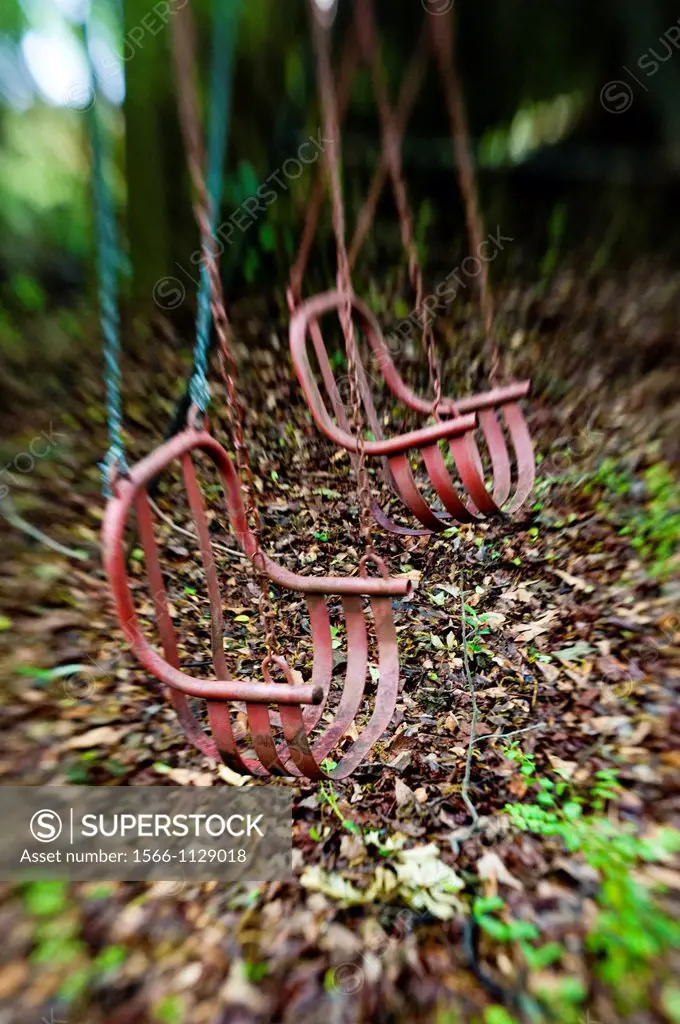 Antique children´s chair swings in a back yard.