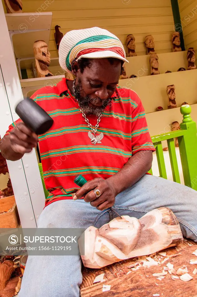 A wood carver works at the Straw Market in Nassau , Bahamas