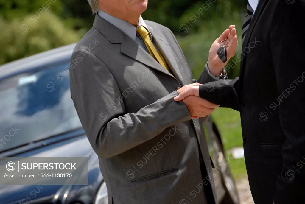 Man selling his car giving the key to the buyer