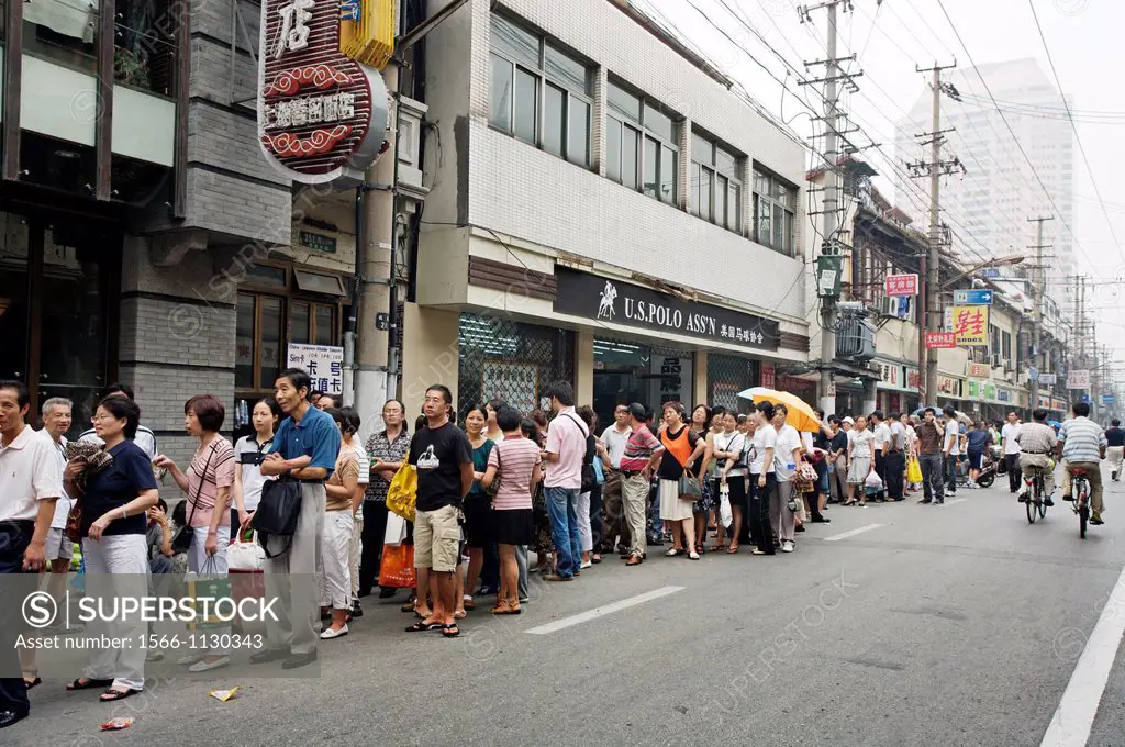 People waiting on a queue to buy cookies, Nanjing Road, Shanghai, China.