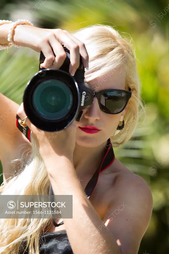 Young blonde girl taking pictures in the Molino de Inca Botanical Garden