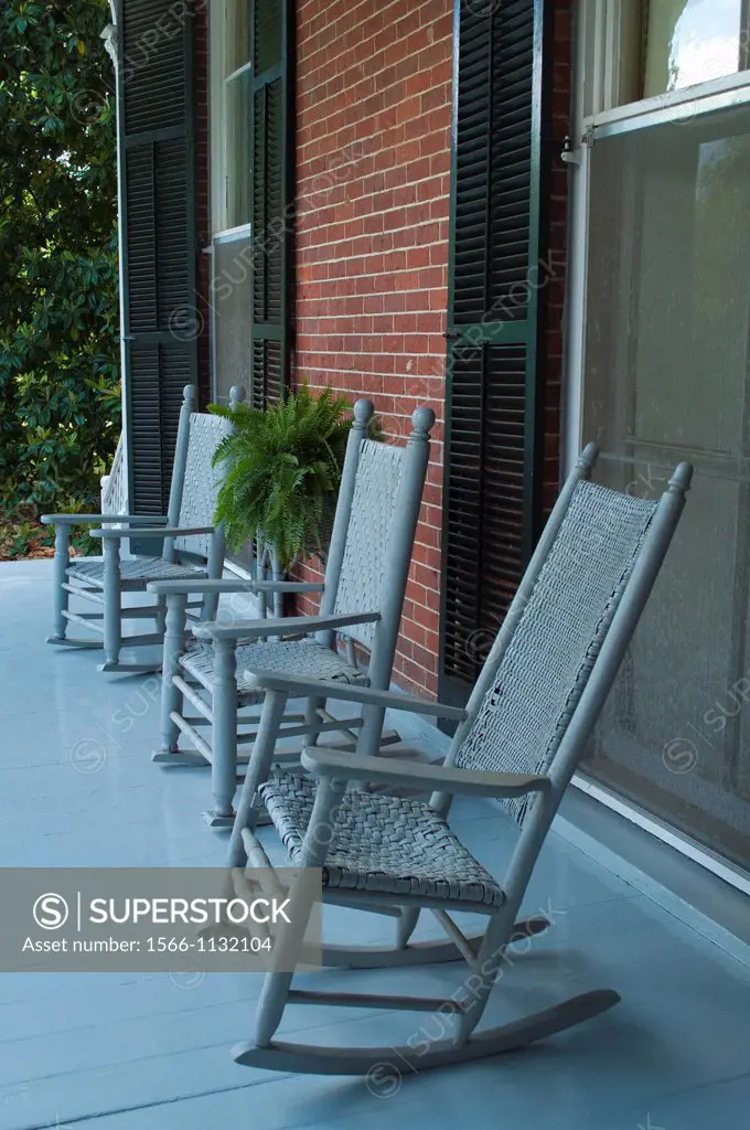 Rocking chairs lined up on the porch of a classic antebellum home