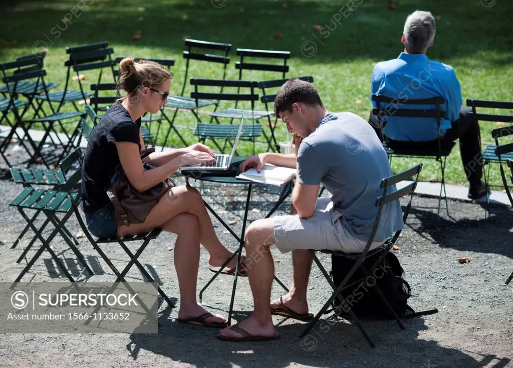 Park visitors read and use a laptop in Bryant Park in New York