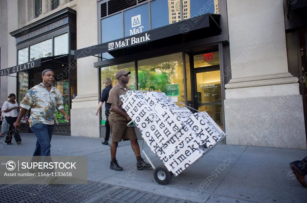 A UPS delivery person laden with packages from the Marimekko store passes an M&T bank branch in New York M&T Bank Corp announced that it is buying Hud...