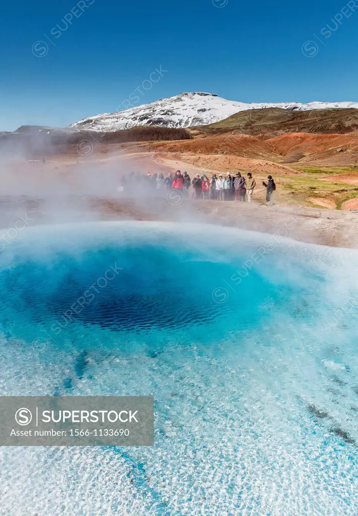 Tourist waiting for Strokkur geyser to erupt, Iceland Strokkur is a fountain geyser in the geothermal area beside the Hvita River  It is one of Icelan...