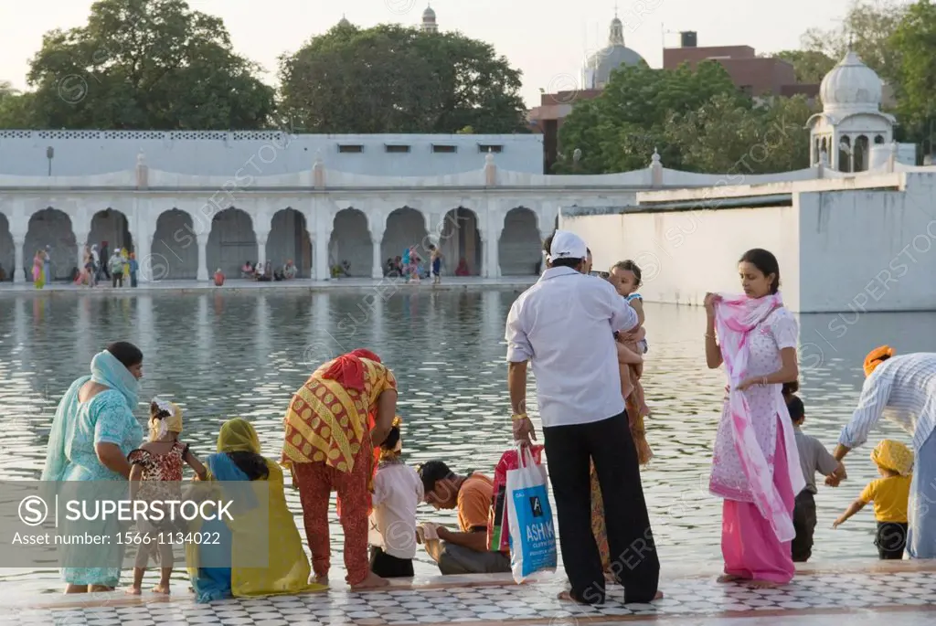 followers by the ´ Sarovar´ pond whose water is considered holy, inside Gurudwara Bangla Sahib, the most prominent Sikh gurdwara, or Sikh house of wor...