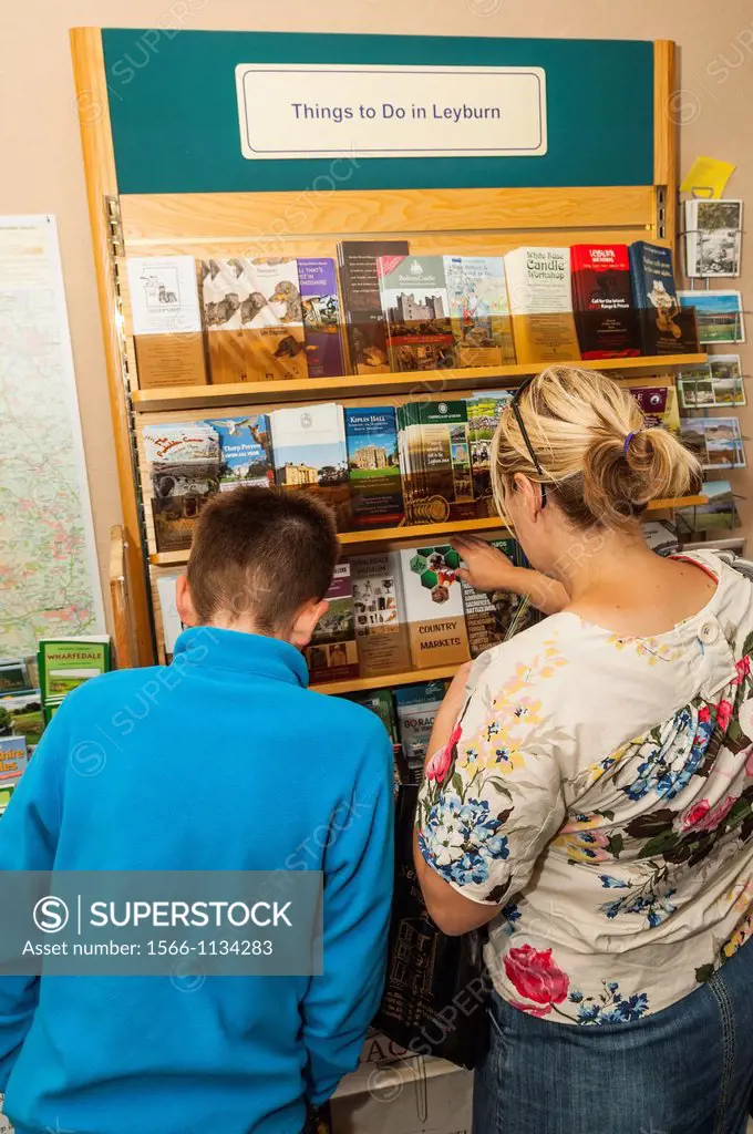 A mother and son looking in tourist information centre at Leyburn in North Yorkshire, England, Britain, Uk