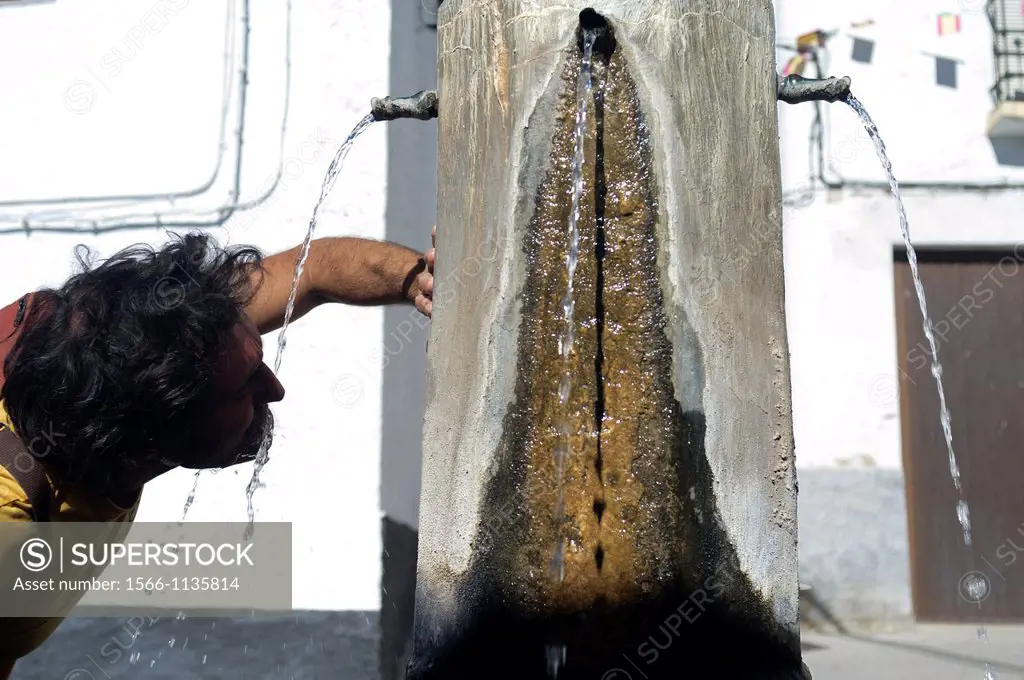 Man drinking water in a typical village, Alpujarras, Granada, Andalucia, Spain