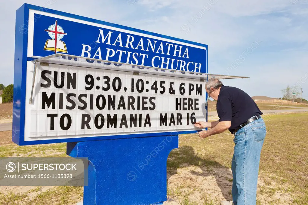 Member changing message on sign outside Maranatha Baptist Church in Ocala, Florida