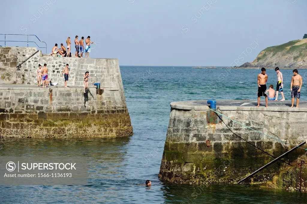Young people jumping and swimming in the harbor, Mundaka, Biscay, Basque Country