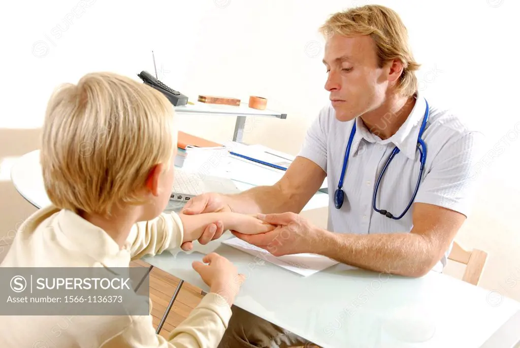 Paediatric examination  Paediatrician examining a young boy´s hand joints