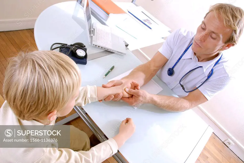 Paediatric examination  Paediatrician examining a young boy´s hand joints