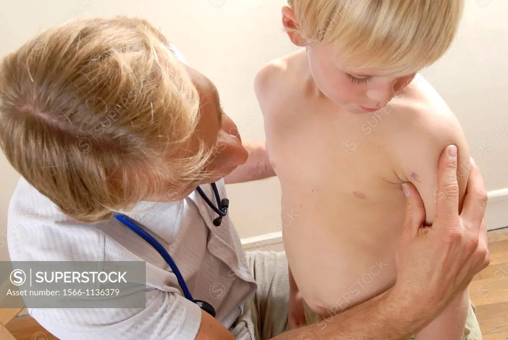Paediatric examination  Paediatrician examining a young boy´s arm stitches