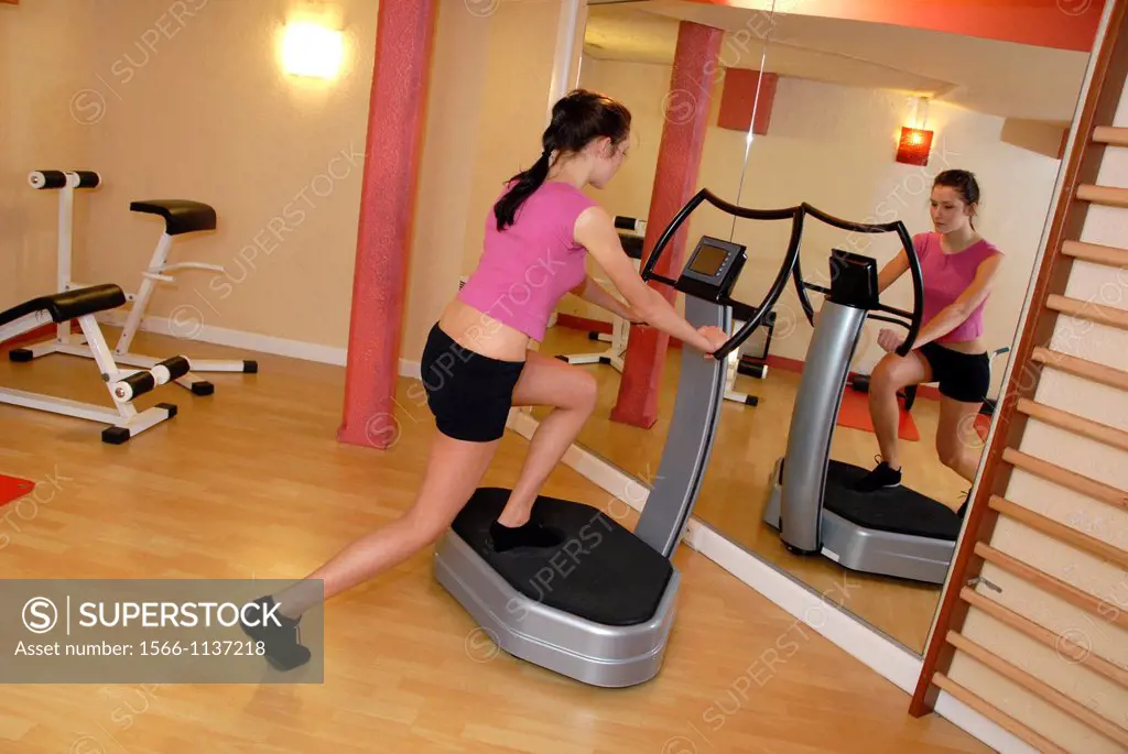 Woman exercising on machine in gym