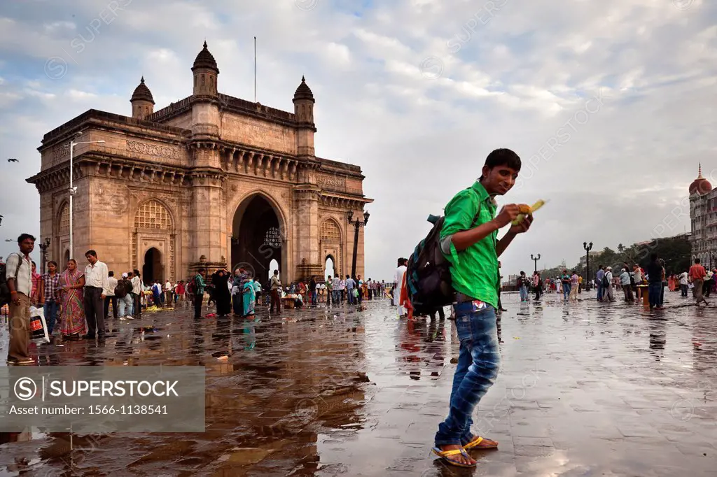 An Indian tourist eats an ear opposite the India Gate