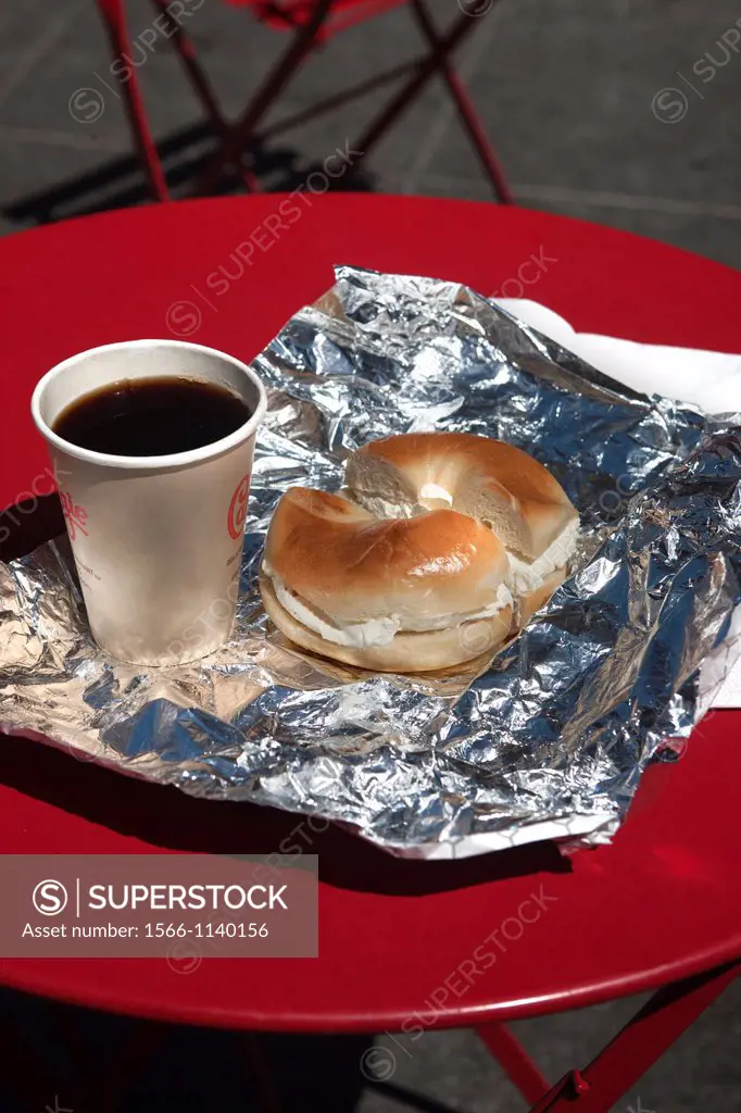 BREAKFAST OF CREAM CHEESE BAGEL AND COFFEE ON RED TABLE IN TIMES SQUARE MANHATTAN NEW YORK CITY USA