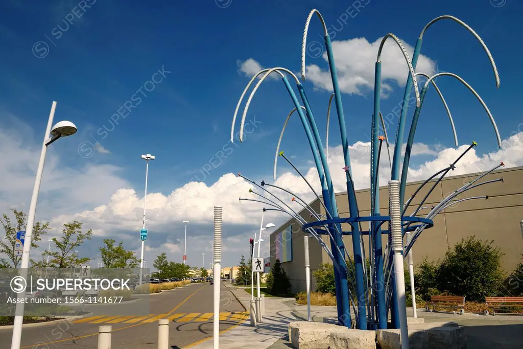 Empty road at a suburban mall entrance with blue sky and clouds