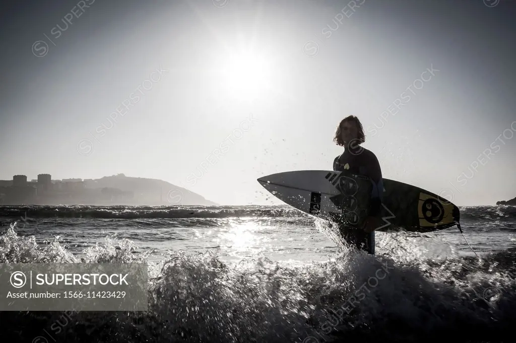 Surfer Pablo Macineira holding surfboard. Orzan Beach. A Coruña. Galicia. Spain.