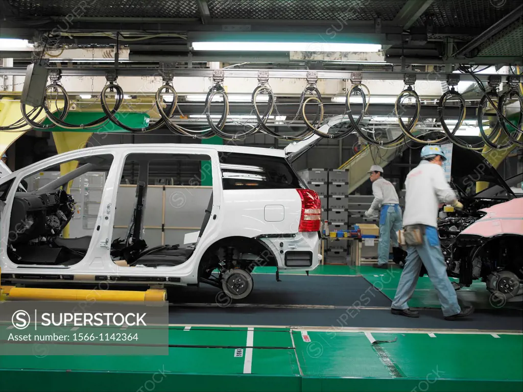 Factory workers producing Toyota cars and vans, work on the assembly line at the Toyota City factory in Japan. This is also where the Toyota Prius is ...