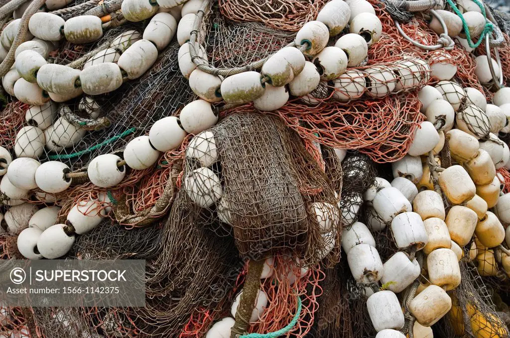 Colorful salmon seine commercial fishing nets stacked on shore in Sitka Alaska , USA