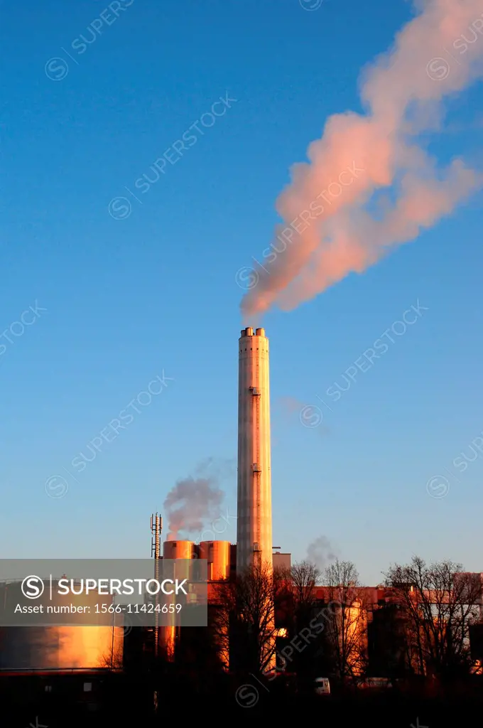 Smoke rises from the chimney of a factory