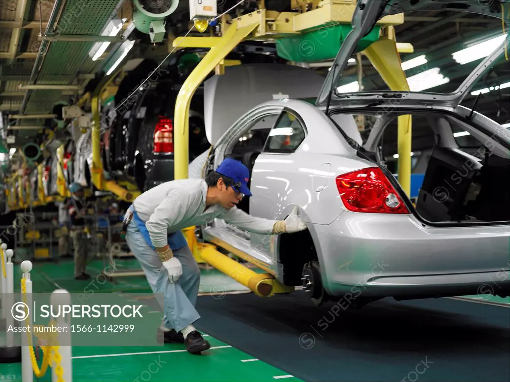 Factory workers producing the hybrid Toyota Prius cars, work on the assembly line at the Toyota City factory in Japan. Here a Scion TC is being inspec...