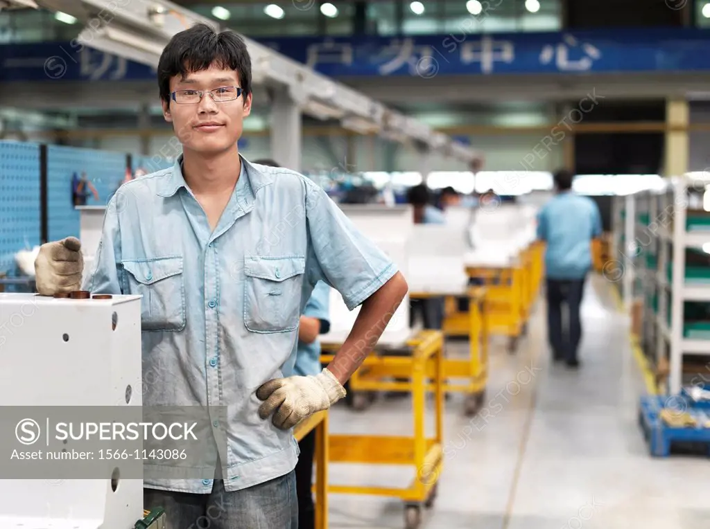 A man standing at a work station where the outer shell of the switchgears are pieced together. Shot in a switchgear factory that produces metal-clad d...
