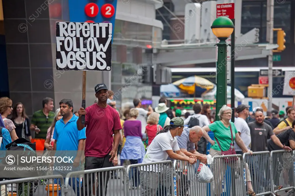 New York, New York - A man in Times Square carries a sign urging people to repent and follow Jesus.